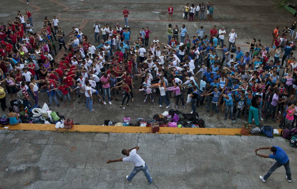 In this March 29, 2014 photo, Cuban school children, known as "pioneers," stretch out at the the Ernesto "Che" Guevara Palace, during festivities marking the anniversaries of the Organization of Cuban Pioneers and of the Union of Communist Youth. in Havana, Cuba. The Havana building is named after the Argentine-born revolutionary famously nicknamed "Che," who is loathed by his detractors and venerated as a symbol of revolutionary resistance by his admirers. (AP Photo/Franklin Reyes)