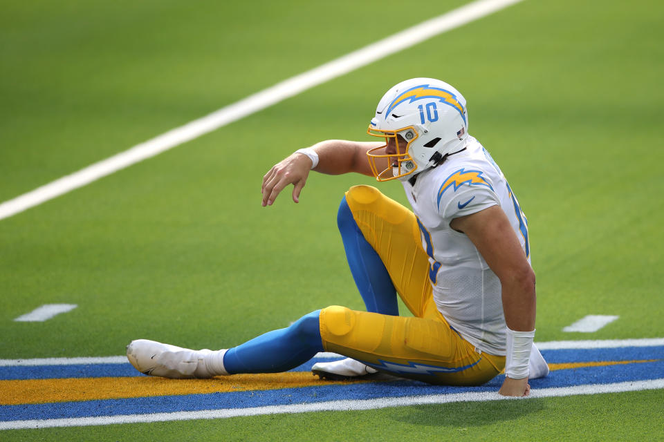 Justin Herbert looks on after being knocked down.