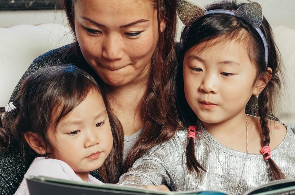 A mother reads to two daughters.