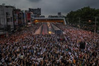 Pro-democracy activists flash three-fingered salutes during a demonstration at Kaset intersection, suburbs of Bangkok, Thailand, Monday, Oct. 19, 2020. Thai authorities worked Monday to stem a growing tide of protests calling for the prime minister to resign by threatening to censor news coverage, raiding a publishing house and attempting to block the Telegram messaging app used by demonstrators. (AP Photo/Sakchai Lalit)