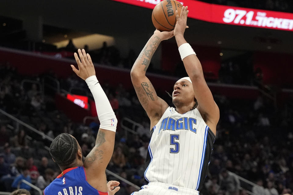 Orlando Magic forward Paolo Banchero (5) shoots over the defense of Detroit Pistons guard Monte Morris during the second half of an NBA basketball game, Sunday, Feb. 4, 2024, in Detroit. (AP Photo/Carlos Osorio)