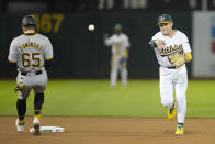 Oakland Athletics shortstop Nick Allen, right, throws to first base after forcing Pittsburgh Pirates' Jack Suwinski (65) out at second base on a double play hit into by Jared Triolo during the seventh inning of a baseball game in Oakland, Calif., Monday, April 29, 2024. (AP Photo/Jeff Chiu)