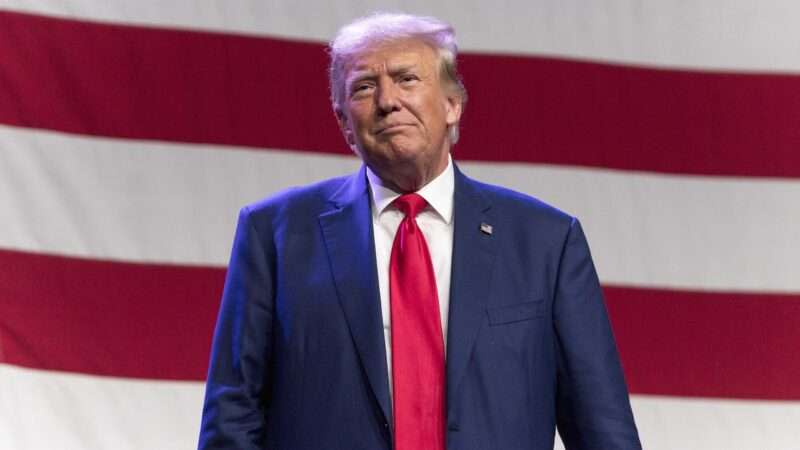 Donald Trump in front of a large American flag