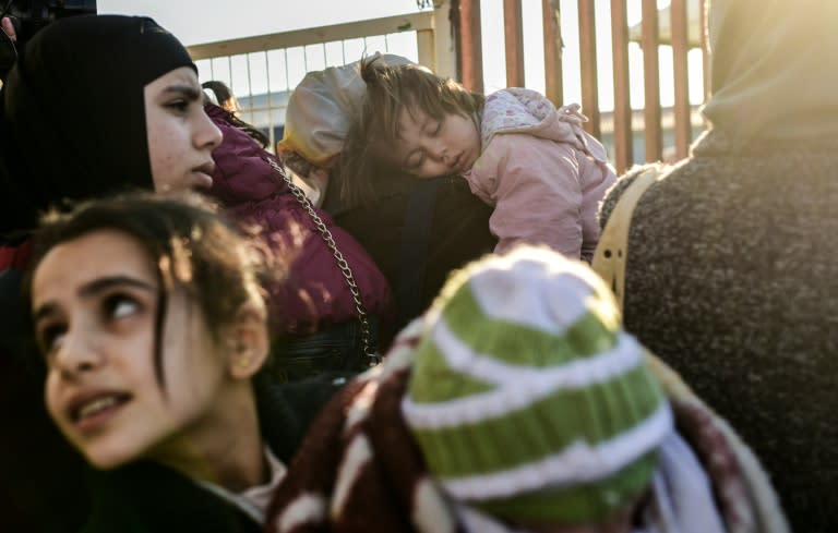 Syrian families line-up on February 8, 2016 at the Turkish Oncupinar border gate near Kilis, southern-central Turkey