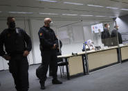 The 96-year-old defendant Irmgard F. sits in an ambulance chair behind a plexiglass screen in a courtroom in Itzehoe, Germany, Tuesday, Oct. 19, 2021. The woman is charged of more than 11,000 counts of accessory to murder. Prosecutors argue that the 96-year-old woman was part of the apparatus that helped the Nazi camp function more than 75 years ago. (Christian Charisius/DPA via AP, Pool)