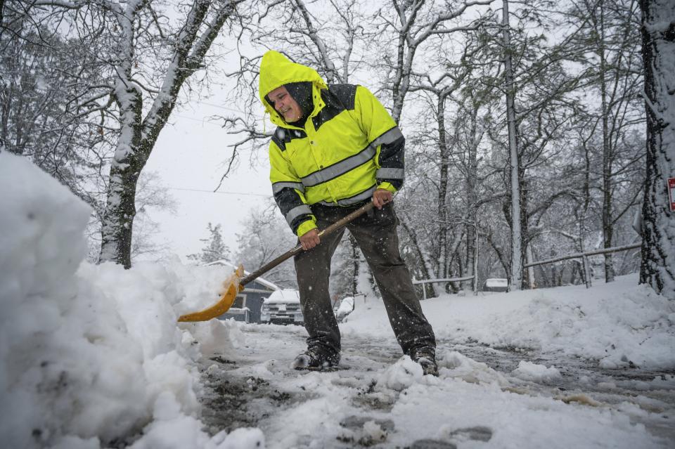 Hayes Condon shovels snow in his driveway on Tuesday, Feb. 28, 2023, in Colfax, Calif. Beleaguered Californians are being hit again by a new winter storm in the already snow-plastered state. Blizzard warnings blanketed the Sierra Nevada on Tuesday, and forecasters warned travel was dangerous. (Hector Amezcua/The Sacramento Bee via AP)