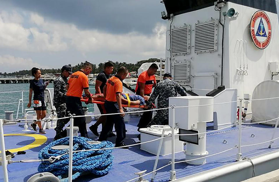 In this photo provided by Philippine Coast Guard in Manila, coast guard personnel carry a survivor to a waiting ambulance after being rescued from a capsized dragon boat off Boracay island resort Wednesday, Sept. 25, 2019, in the central Philippines. The coast guard says seven rowers drowned and 14 others were rescued when their dragon boat was suddenly lashed by strong waves and overturned in the central Philippines. (Philippine Coast Guard Via AP)