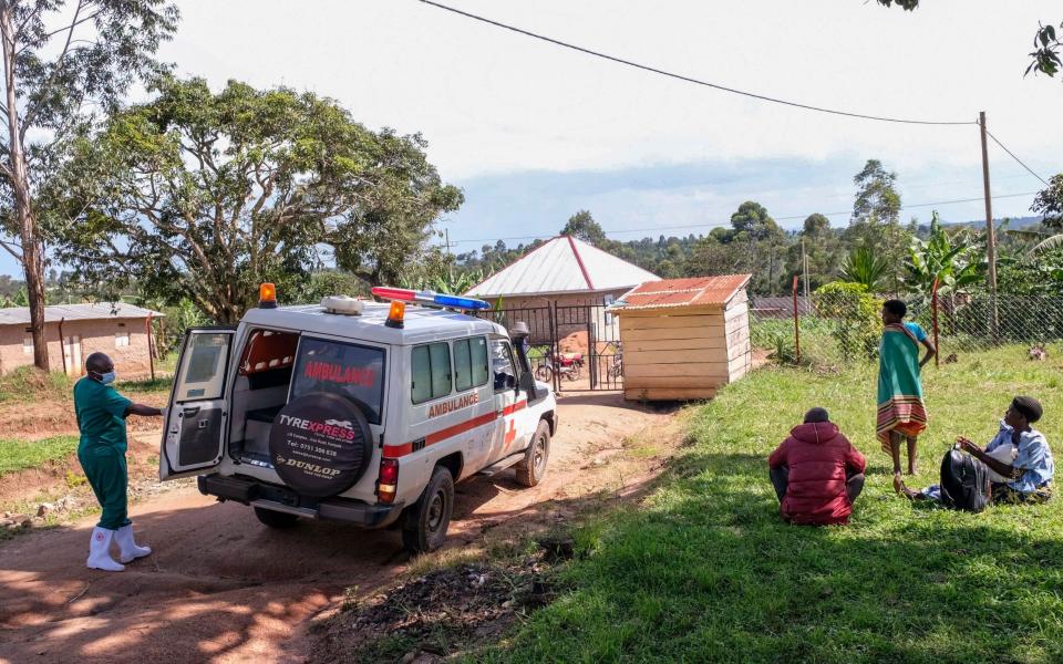 A medical officer from the Uganda Red Cross Society instructs people with suspected Ebola symptoms to enter an ambulance, in Madudu, near Mubende, in Uganda - Hajarah Nalwadda/AP