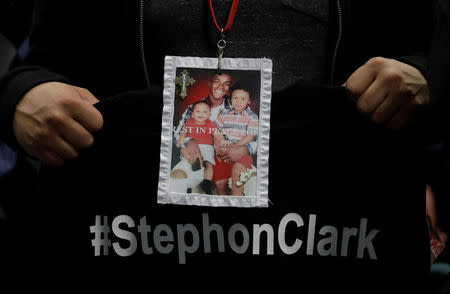 A mourner holds up a photo of police shooting victim Stephon Clark during the funeral services for Clark at Bayside Of South Sacramento Church in Sacramento, California, March 29, 2018. Jeff Chiu/Pool via Reuters