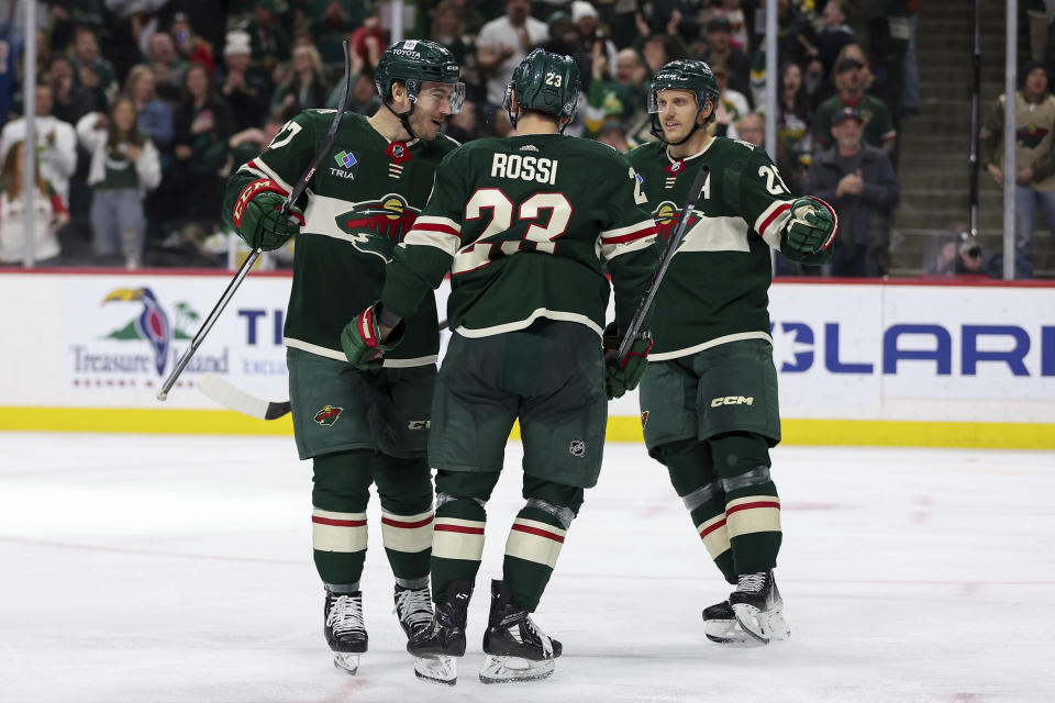 Minnesota Wild center Marco Rossi is congratulated for his goal by center Jacob Lucchini and defenseman Jonas Brodin during the third period of an NHL hockey game against the Vancouver Canucks, Monday, Feb. 19, 2024, in St. Paul, Minn. (AP Photo/Matt Krohn)
