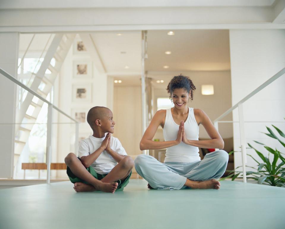 Exercising with loved ones is one way to support mental well-being. <a href="https://www.gettyimages.com/detail/photo/mother-and-son-practicing-yoga-at-home-ground-view-royalty-free-image/200265184-002" rel="nofollow noopener" target="_blank" data-ylk="slk:Commercial Eye/The Image Bank via Getty Images;elm:context_link;itc:0;sec:content-canvas" class="link ">Commercial Eye/The Image Bank via Getty Images</a>