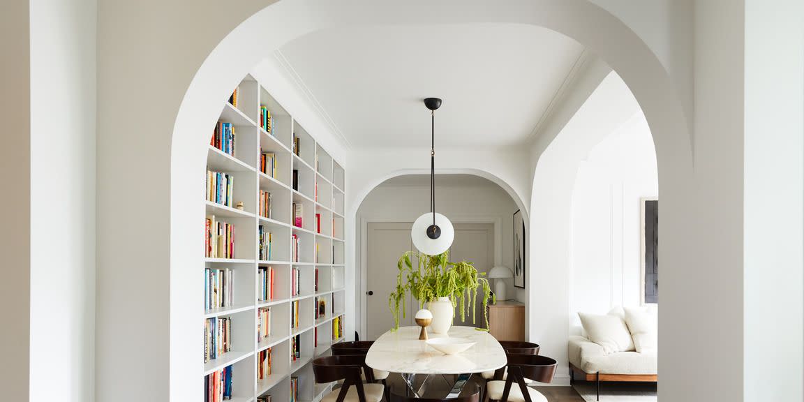 home library in brooklyn apartment designed by space exploration featuring a wall of books framed by arches