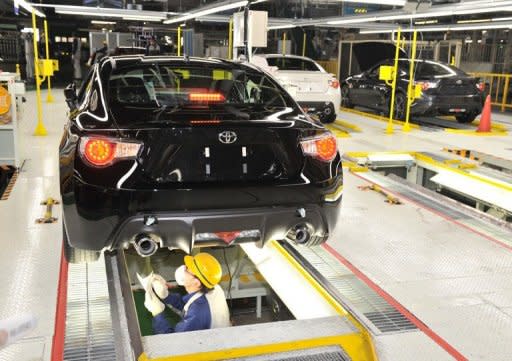 This file photo shows a worker checking out a car body at a plant in Ota-city, Gunma prefecture, in March. Japan's factory output turned down unexpectedly last month, according to official data released on Monday, stoking concerns that turmoil overseas is damaging recovery in the world's third-largest economy