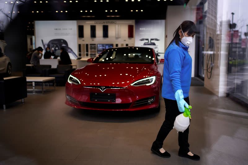 A worker sanitises a Tesla showroom, in a Shanghai shopping complex, as the country is hit by an outbreak of the novel coronavirus, Shanghai