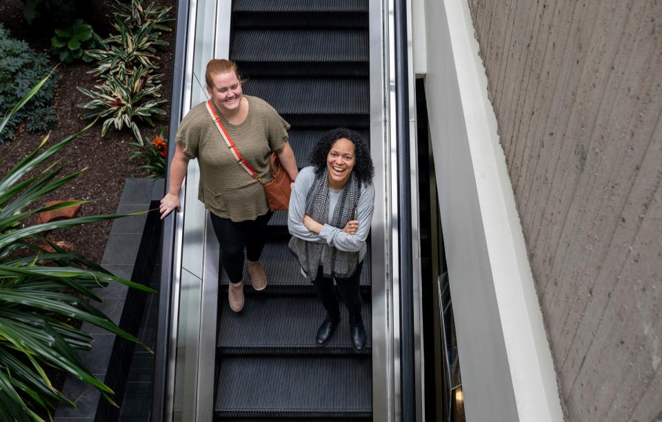 Dana Tilden, left, and Stephanie Brooks, two General Motors employees, smile as they take the escalator down to the food court area inside the Renaissance Center during lunchtime in Detroit on Wednesday, Feb. 28, 2024.