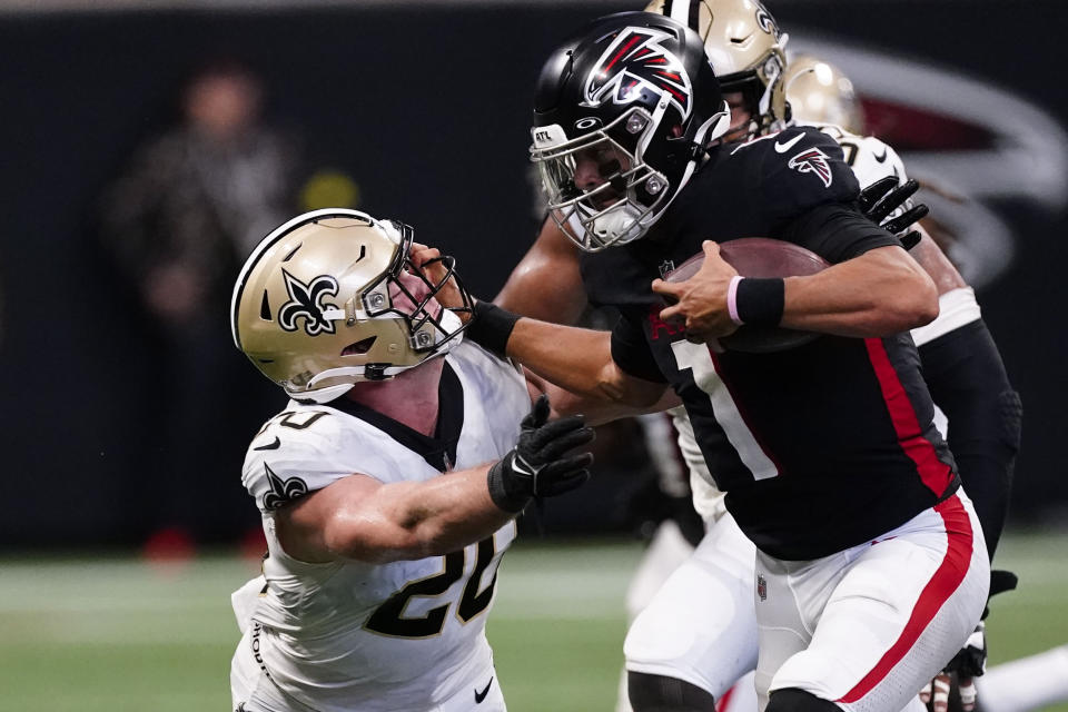 Atlanta Falcons quarterback Marcus Mariota (1) hits New Orleans Saints linebacker Pete Werner (20) during the second half of an NFL football game, Sunday, Sept. 11, 2022, in Atlanta. (AP Photo/John Bazemore)