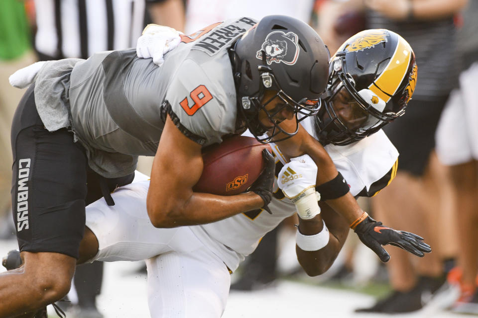 Oklahoma State wide receiver Bryson Green (9) struggles forward while being tackled by Arkansas-Pine Bluff defensive back Nathan Seward during the first half of an NCAA college football game, Saturday, Sept. 17, 2022, in Stillwater, Okla. (AP Photo/Brody Schmidt)