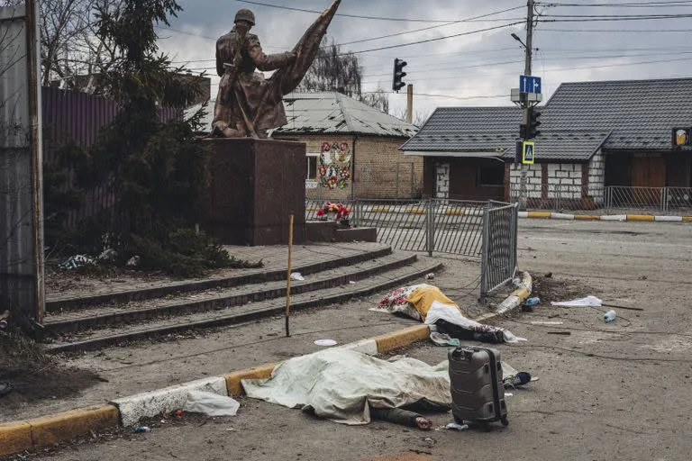 Los cad&#xe1;veres de las personas muertas por los bombardeos rusos yacen cubiertos en la calle en la ciudad de Irpin, Ucrania, el domingo 6 de marzo de 2022. 