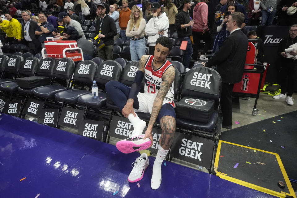 Washington Wizards forward Kyle Kuzma (33) takes off his shoes following an NBA basketball game against the Utah Jazz, Monday, March 4, 2024, in Salt Lake City. (AP Photo/Rick Bowmer)