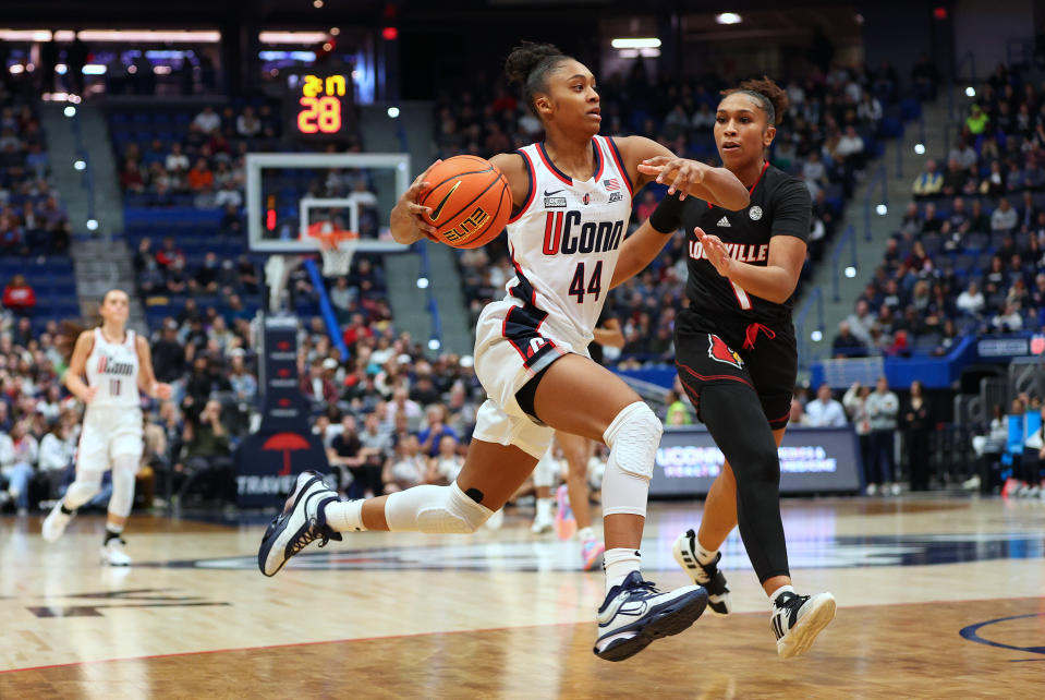 HARTFORD, CT - DECEMBER 16: UConn Huskies guard Aubrey Griffin (44) drives to the basket against Louisville Cardinals guard Sydney Taylor (1) during the women's college basketball game between Louisville Cardinals and UConn Huskies on December 16, 2023, at the XL Center in Hartford, CT. (Photo by M. Anthony Nesmith/Icon Sportswire via Getty Images)