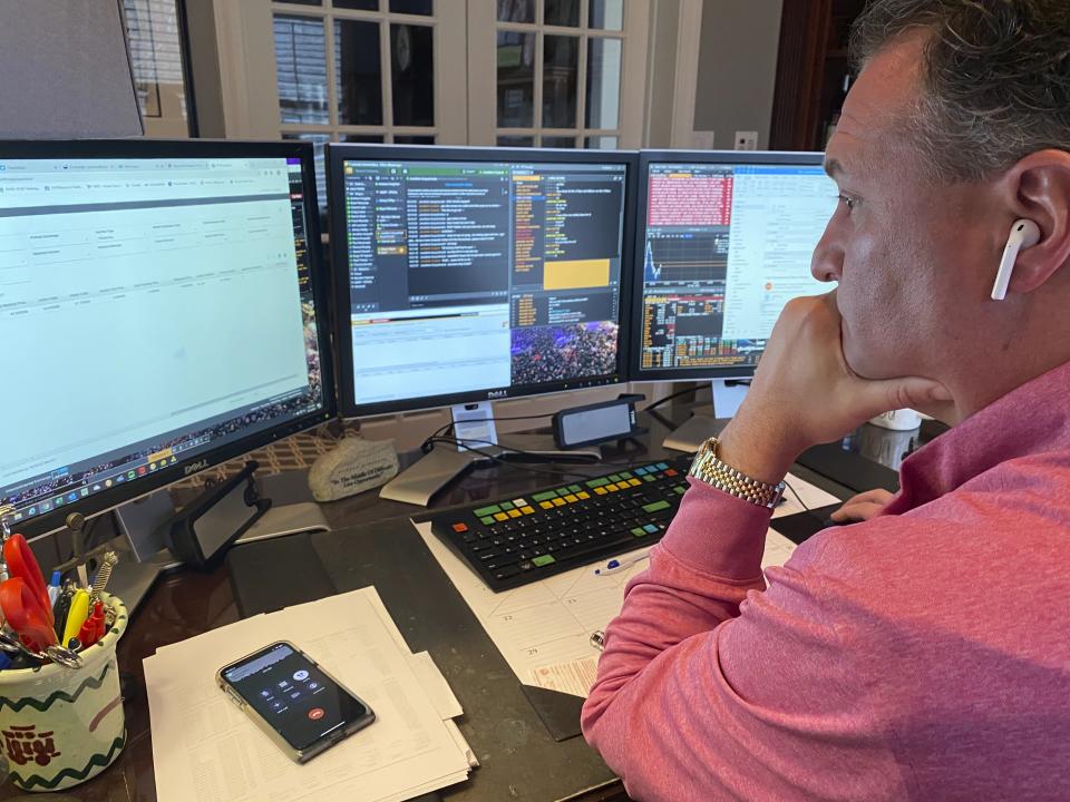 In this image provided by Jonathan Corpina, Jonathan Corpina, Senior Managing Partner at Meridian Equity Partners Inc., who normally works on the New York Stock Exchange trading floor, works in his home office in Armonk, NY., Wednesday, March 25, 2020. Stocks are wobbling in tentative trading Wednesday as a historic, worldwide rally downshifts dramatically after just a day. (Danielle Corpina/Courtesy Jonathan Corpina via AP)