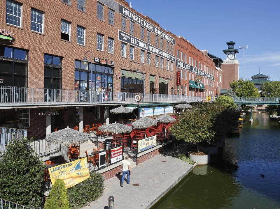 This Oct. 9, 2013 photo shows shops and restaurants line the Bricktown Canal in Oklahoma City. Bricktown, an old warehouse district, has been transformed into a major entertainment hotspot. (AP Photo/Sue Ogrocki)