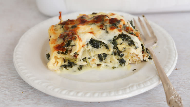 spinach and chicken lasagna piece on white pate