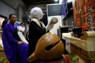 A 'robot priest' wearing a Buddhist robe chants sutras at it beats a wooden fish during its demonstration at Life Ending Industry EXPO 2017 in Tokyo, Japan August 23, 2017. REUTERS/Kim Kyung-Hoon