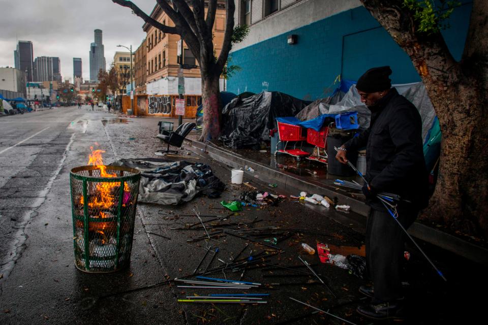 A homeless man makes a fire from trash to keep warm on Thanksgiving Day in Los Angeles. The Supreme Court was asked to let cities criminalize homelessness.
