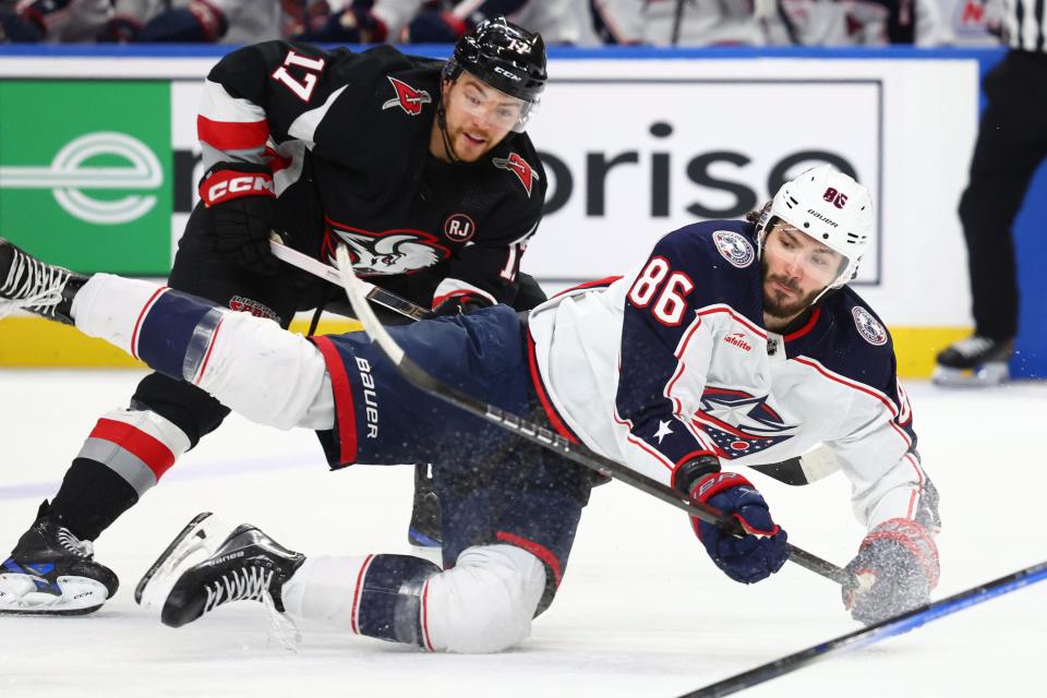 Columbus Blue Jackets right wing Kirill Marchenko (86) is brought down by Buffalo Sabres center Tyson Jost (17) during the second period of an NHL hockey game Tuesday, Dec. 19, 2023, in Buffalo, N.Y. (AP Photo/Jeffrey T. Barnes)