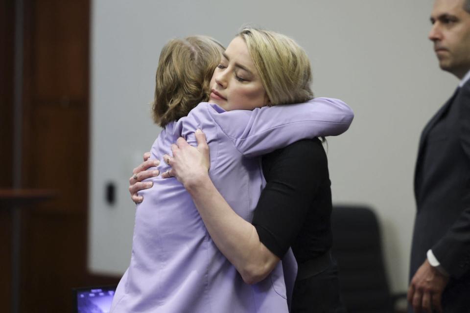 Amber Heard hugs her lawyer Elaine Bredehoft after the jury announced split verdicts in favor of both her ex-husband Johnny Depp and Heard