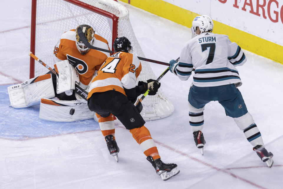 Philadelphia Flyers goaltender Felix Sandstrom (32) and defenseman Nick Seeler (24) block an attempt on goal by San Jose Sharks center Nico Sturm (7) during the third period of an NHL hockey game, Sunday, Oct. 23, 2022, in Philadelphia. (AP Photo/Laurence Kesterson)