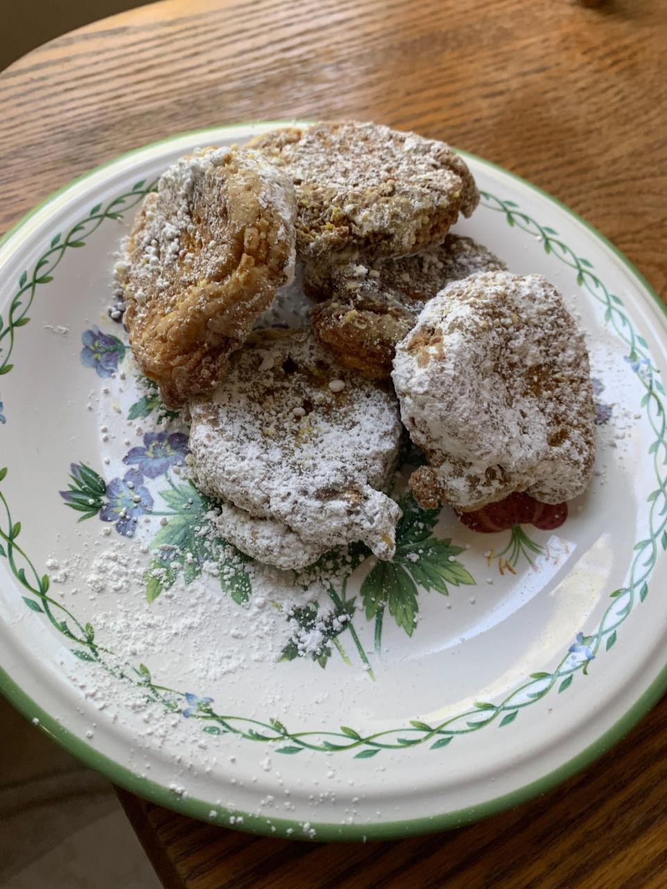 a plate of pumpkin fritters with powdered sugar