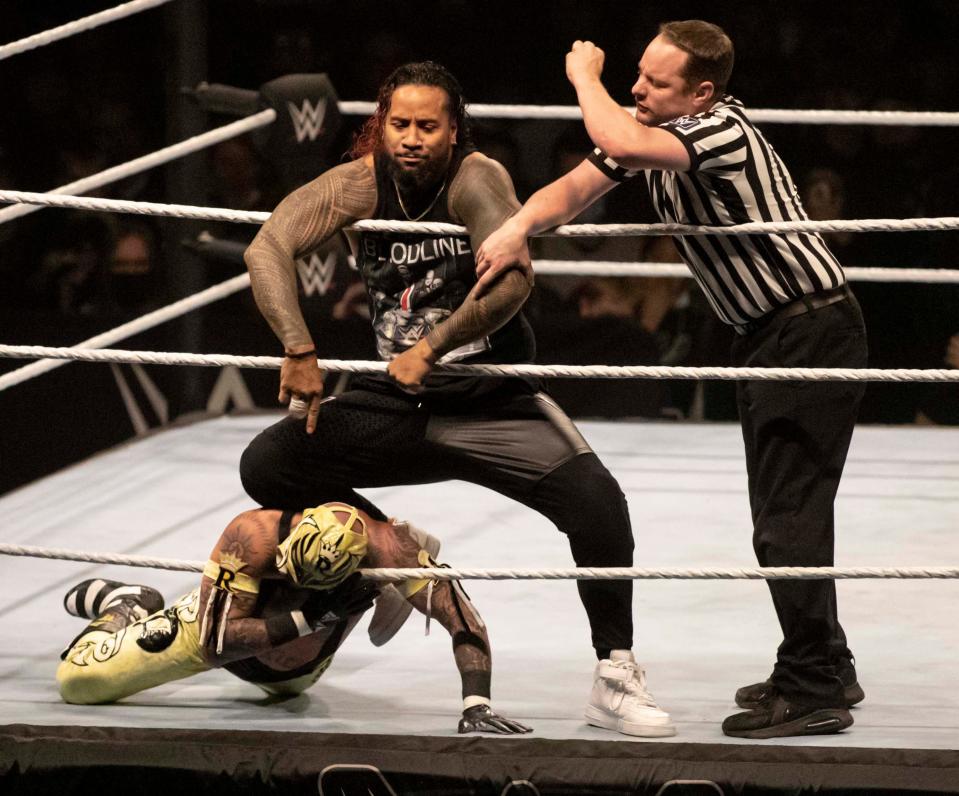 WWE Usos knees Rey Mysterio neck into the bottom rope on Saturday, Dec. 18, 2021, at the BMO Harris Bank Center in Rockford.