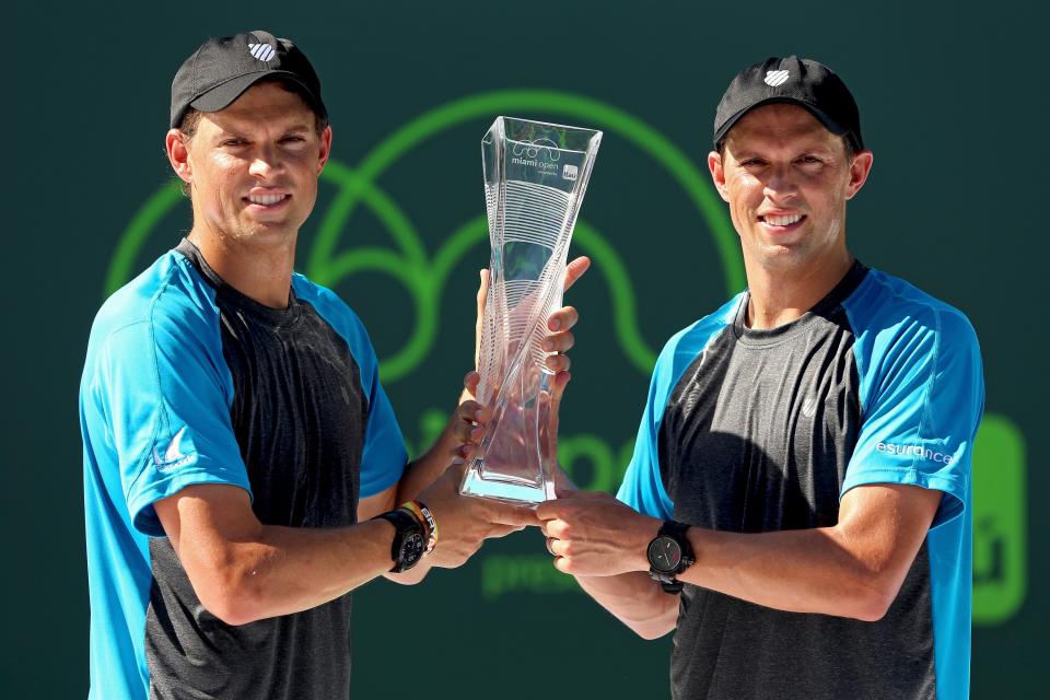 The Bryans hold up the Butch Buchholz Trophy after defeating Vasek Pospisil of Canada and Jack Sock in the doubles final (Matthew Stockman/Getty Images)