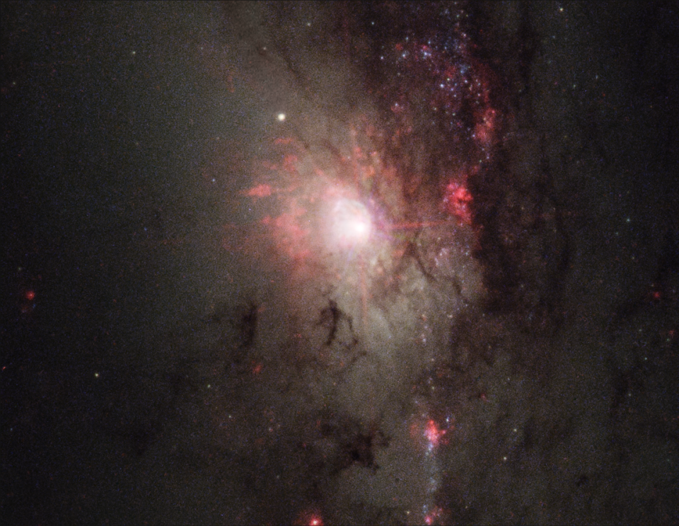 A false-color image of an "active galactic nucleus" (or AGN) at the center of a glowing, red galaxy. This galaxy could go through a midlife crisis.