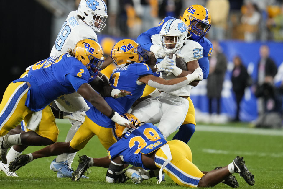 North Carolina running back Omarion Hampton (28) is gang-tackled during the first half of an NCAA college football game against Pittsburgh in Pittsburgh, Saturday, Sept. 23, 2023. (AP Photo/Gene J. Puskar)