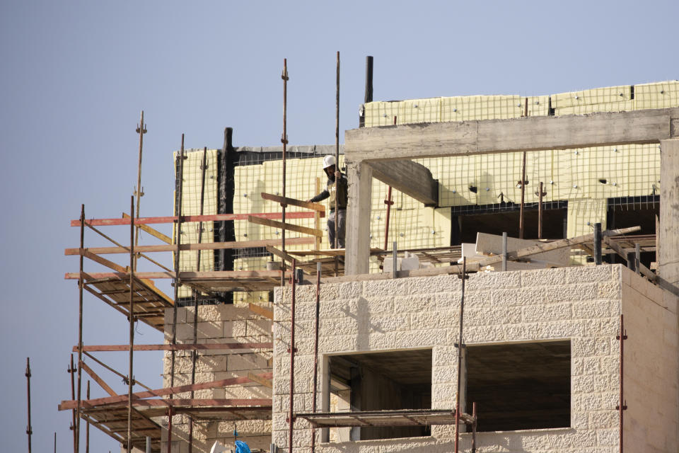 A Palestinian laborer works on a new building in the West Bank Jewish settlement of Efrat, Tuesday, March 16, 2021. Israel went on an aggressive settlement spree during the Trump era, according to an AP investigation, pushing deeper into the occupied West Bank than ever before and putting the Biden administration into a bind as it seeks to revive Mideast peace efforts. (AP Photo/Maya Alleruzzo)