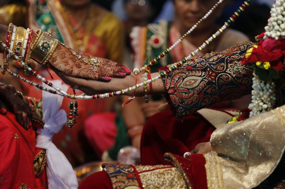 <span class="caption">A bride and a groom perform rituals during a mass wedding in Surat India.</span> <span class="attribution"><span class="source">Ajit Solanki/AAP</span></span>