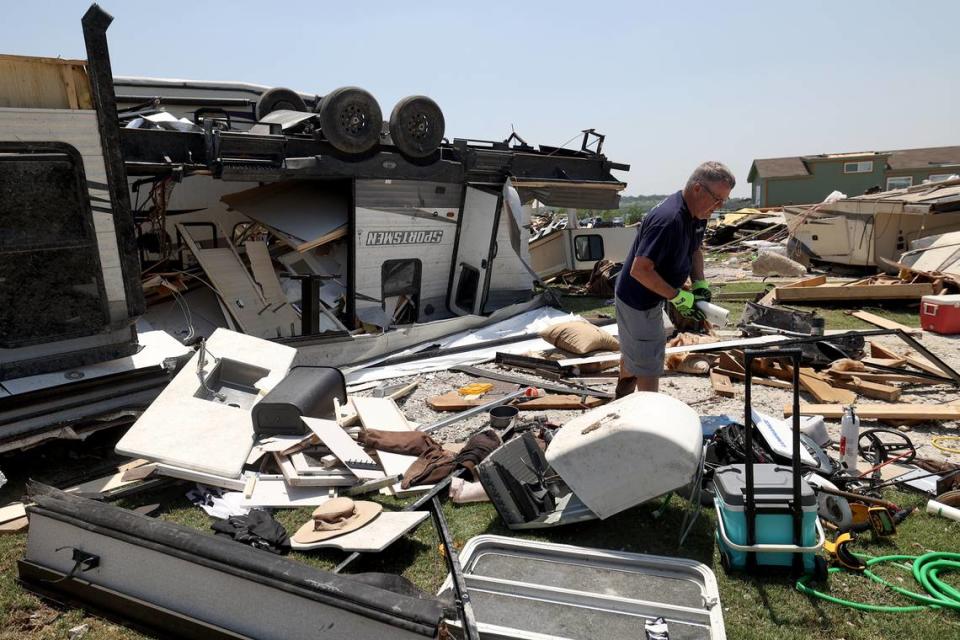 Sam Lee cleans up the debris of his brother’s RV at Ray Roberts Marina in Sanger on Sunday, May 26, 2024.