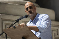 British novelist Hari Kunzru reads part of "The Satanic Verses" during a reading event in solidarity of support for author Salman Rushdie outside the New York Public Library, Friday, Aug. 19, 2022, in New York. (AP Photo/Yuki Iwamura)