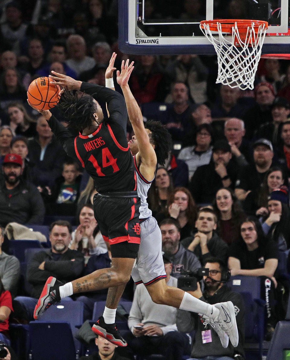 San Diego State guard Reese Waters (14) shoots while pressured by Gonzaga guard Ryan Nembhard during the second half of an NCAA college basketball game, Friday, Dec. 29, 2023, in Spokane, Wash. San Diego State won 84-74. (AP Photo/Young Kwak)