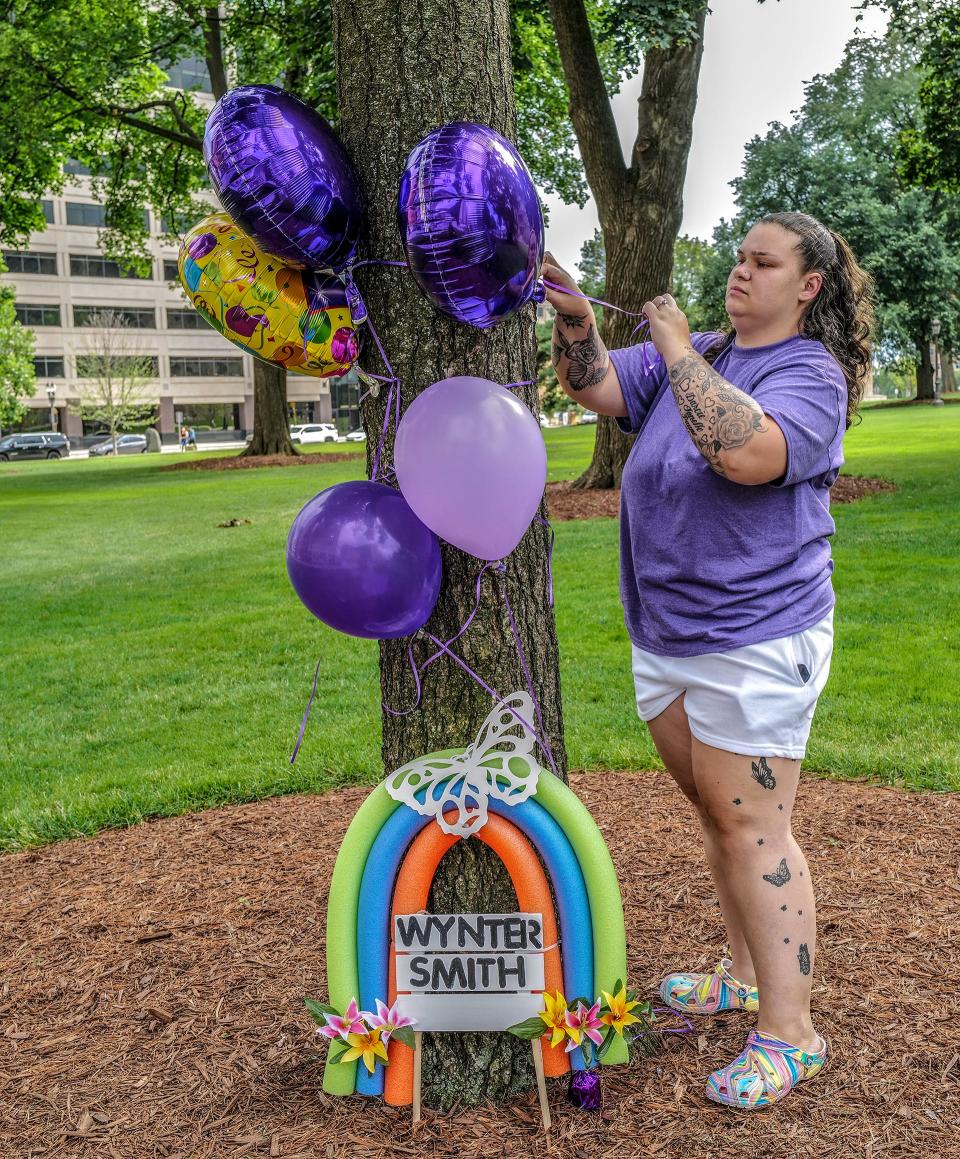 Mackenzie Winton starts assembling a memorial for slain 2-year-old Wynter Cole-Smith on the Capitol grounds Saturday, July 8, 2023. About 100 people showed up and added to the memorial.