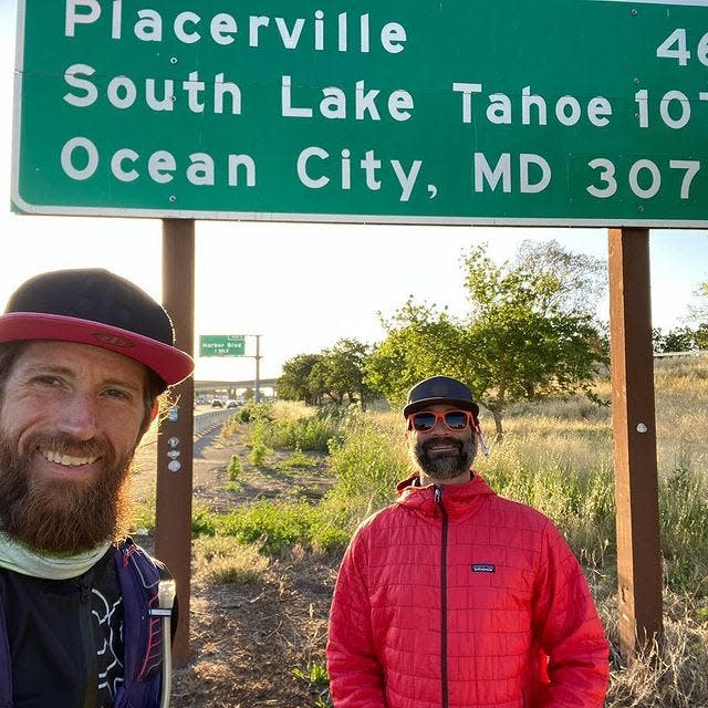 Ultra-runner Michael Wardian, left, and crew chief Eric Belz pose near a road sign outside Sacramento, California on May 3, 2022.