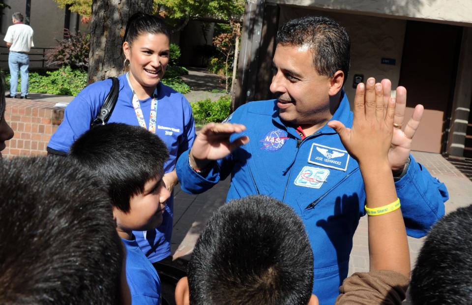 Former astronaut Jose Hernandez high-fives a student from Dolores Huerta Elementary School who was one of 670 Stockton Unified students visiting San Joaquin Delta College on Oct. 22, 2010, to participate in a Jose Hernandez Reaching for Stars Foundation event.