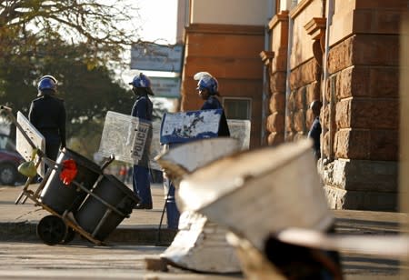 Riot police officers keep watch outside the Tredgold Building Magistrate court in Bulawayo