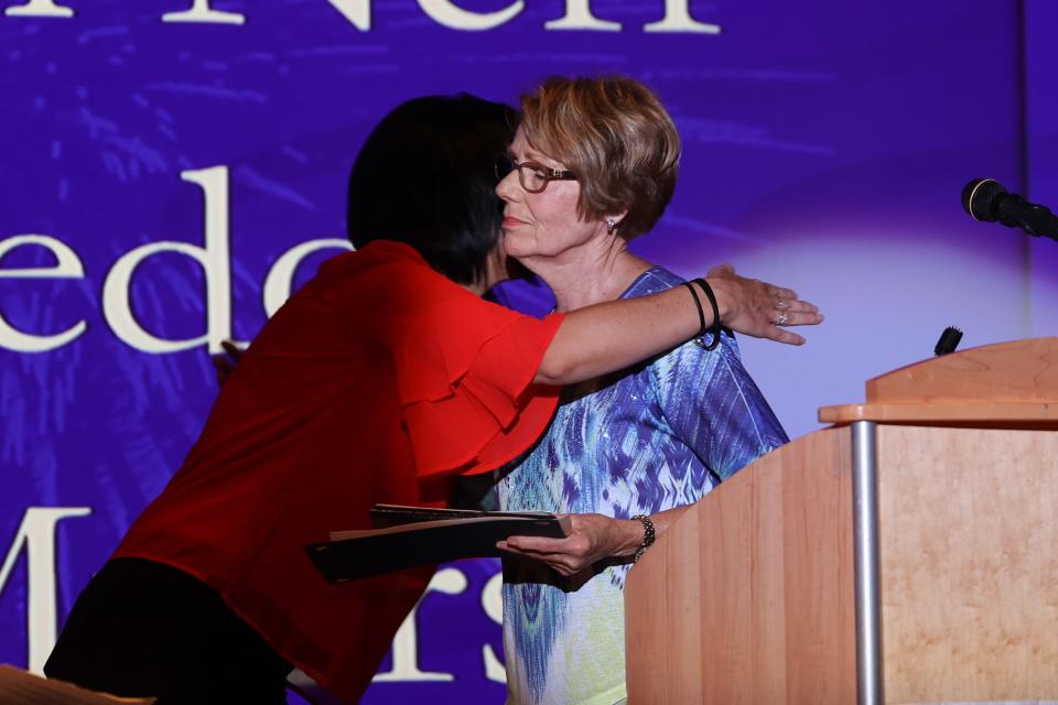 Ravenna Chamber of Commerce Executive Director Ryann Kuchenbecker hugs Carol Mills, wife of the late Gene Mills, after she accepted the award on his behalf during the 2022 Raven Awards.
