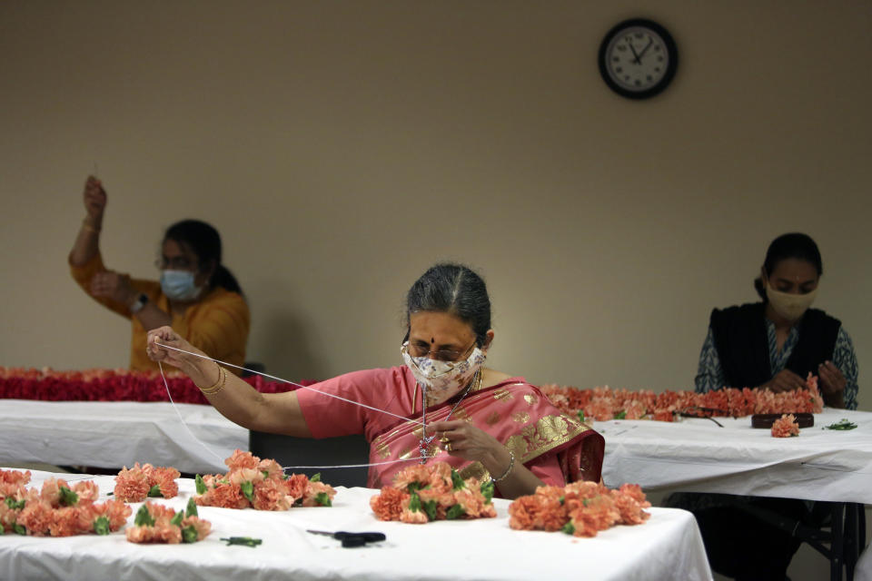 Thiru Panchalingam, center, assembles decorations made of carnations, Tuesday, June 22, 2021, in preparation for Maha Kumbhabhishekam, a five-day rededication ceremony at the Sri Venkateswara Temple near Pittsburgh that concluded Sunday, June 27, 2021. Built in the 1970s, the Sri Venkateswara Temple is the oldest major Hindu temple in the country. Maha Kumbhabhishekams occur about every 12 years and involve ceremonies to reenergize the temple and its deities. (AP Photo/Jessie Wardarski)