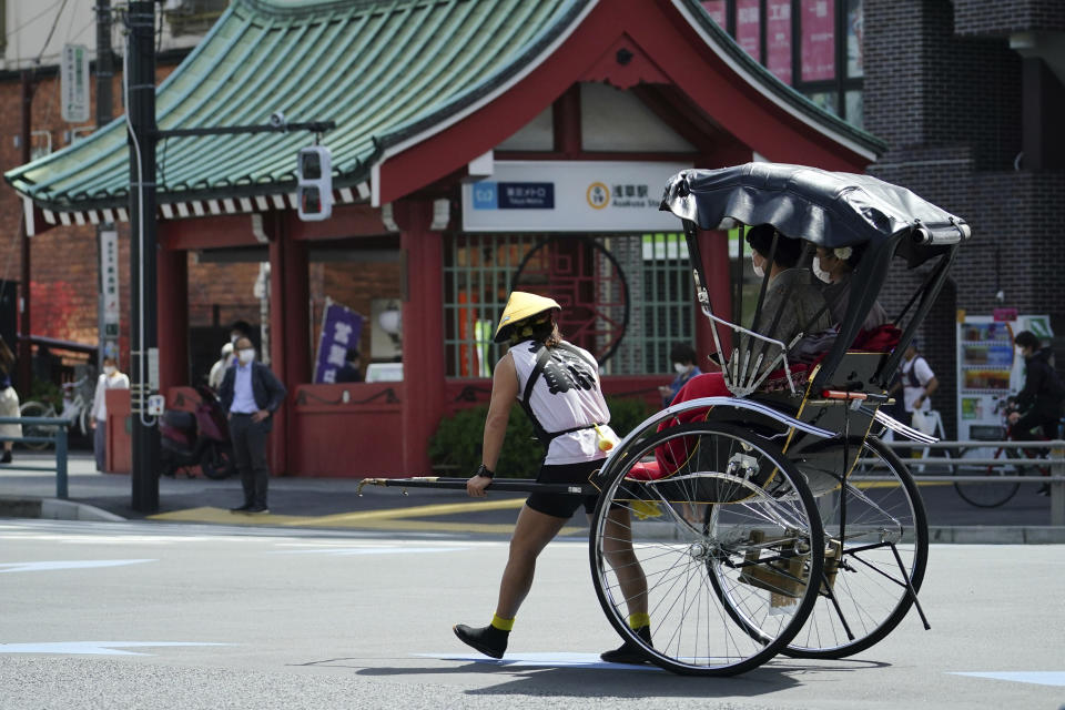 A rickshaw puller carries tourists near Sensoji Buddhist temple at Tokyo's Asakusa district in Tokyo on March 31, 2021. The Japanese economy contracted at an annual rate of 5.1% in January-March, slammed by a plunge in spending over the coronavirus pandemic, according to government data released Tuesday, May 18, 2021. (AP Photo/Eugene Hoshiko)