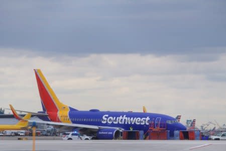 Emergency personnel monitor the damaged engine of Southwest Airlines Flight 1380, which diverted to the Philadelphia International Airport this morning after the airline crew reported damage to one of the aircraft's engines, on a runway in Philadelphia, Pennsylvania U.S. April 17, 2018.  REUTERS/Mark Makela